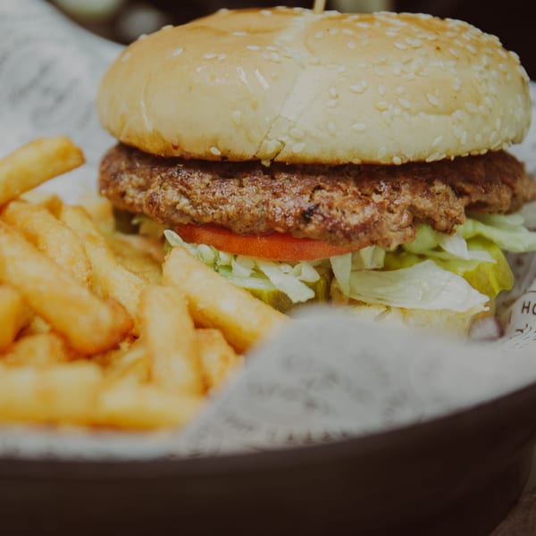 A Mozillas Kitchen burger with lettuce, tomato, and pickles, served with golden french fries.